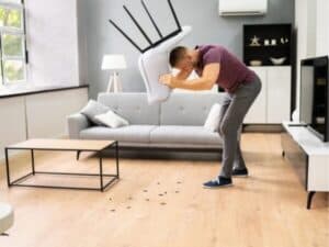uomo che solleva una sedia trova scarafaggi neri in casa